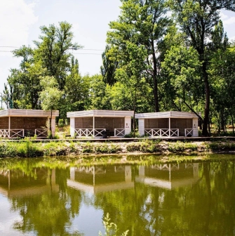 X-Park in Kyiv - cozy wooden gazebos for recreation standing on the river bank surrounded by green trees