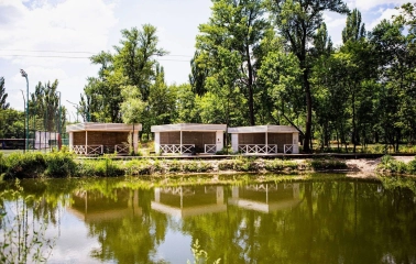 X-Park in Kyiv - cozy wooden gazebos for recreation standing on the river bank surrounded by green trees