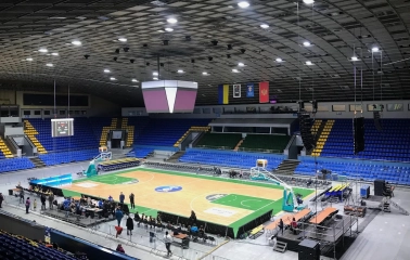 Palats Sportu in Kyiv - brightly lit basketball court parquet surrounded by blue stands