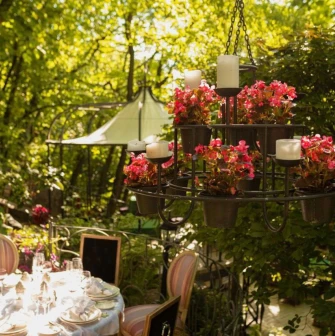 Terasa - flower chandelier above table on sunny garden terrace