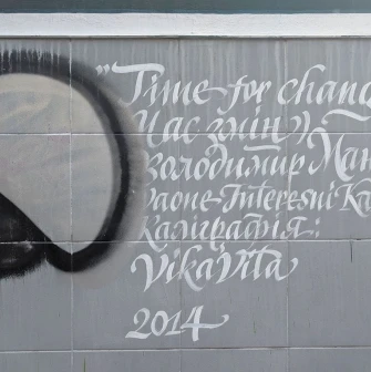Time of Changes in Kyiv - tile on the wall with a white calligraphic caption of the mural