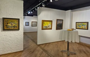 Muzei Suchasnoho Mystetstva in Kyiv - cozy gallery corner with textured white brick walls featuring landscape paintings