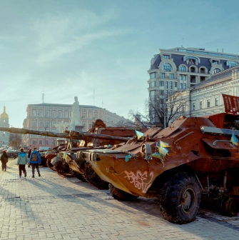 Mykhailivska Square in Kyiv - people gathered around a row of rusty destroyed tanks