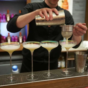Bartender preparing a cocktail behind the Pink Freud bar counter