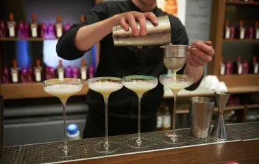 Bartender preparing a cocktail behind the Pink Freud bar counter