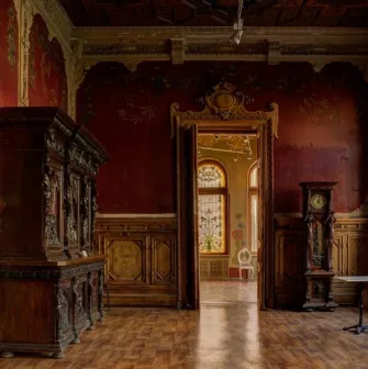 Chocolate house - hall with red walls, antique wooden furniture and stained glass windows