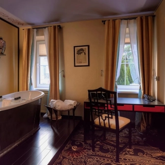 Vozdvyzhenskyi in Kyiv - bathroom with freestanding tub and black desk by window