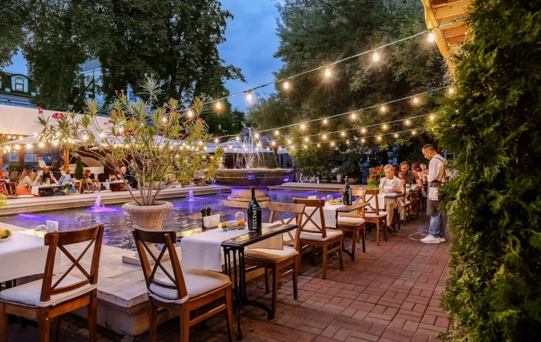 Restaurant Vero Vero - luxurious outdoor terrace with seating next to a decorative stone fountain