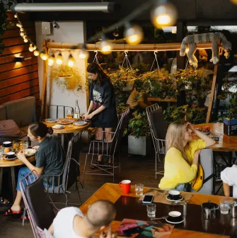 Restaurant Ulyublenyi Diadia - outdoor terrace with warm lights and customers dining