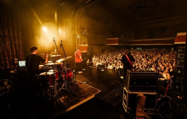Mala Opera in Kyiv - live music performance in the vintage hall with a drummer on stage overlooking a dense crowd of excited fans