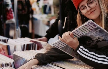 A girl in a red hat looks through records at the Podilsky Shuk vintage market in Kyiv