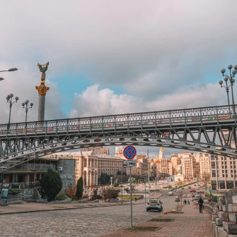 Thousand Years Bridge in Kyiv- bridge arching over the street with the monument behind
