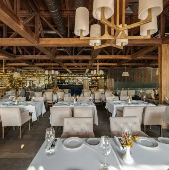 Spacious restaurant dining hall featuring wooden beams and stylish lighting