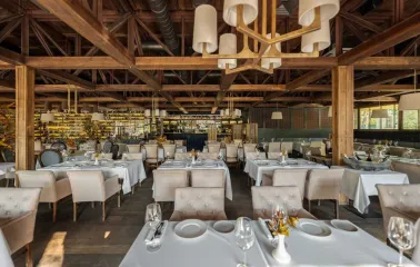 Spacious restaurant dining hall featuring wooden beams and stylish lighting
