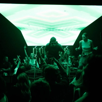 Stage with a DJ at the Juice / NoCap club in Kyiv with bright green lighting