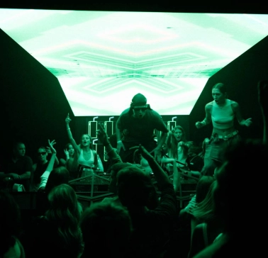 Stage with a DJ at the Juice / NoCap club in Kyiv with bright green lighting
