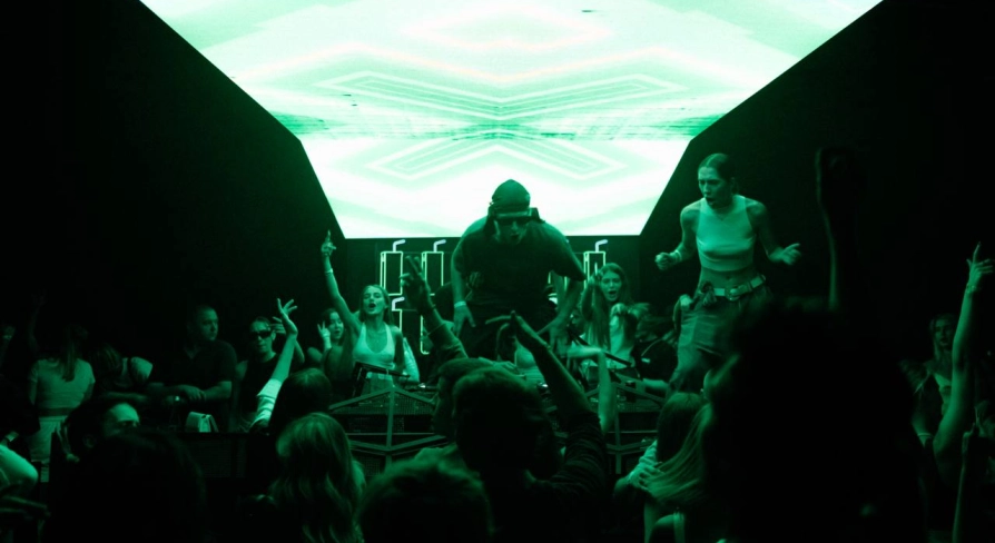 Stage with a DJ at the Juice / NoCap club in Kyiv with bright green lighting