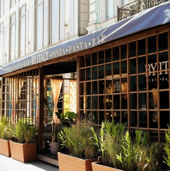 By Italy - elegant restaurant facade with large arched windows