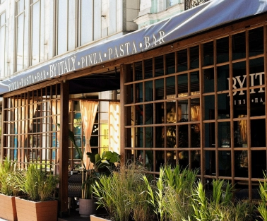 By Italy - elegant restaurant facade with large arched windows