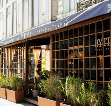 By Italy - elegant restaurant facade with large arched windows