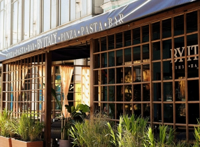 By Italy - elegant restaurant facade with large arched windows