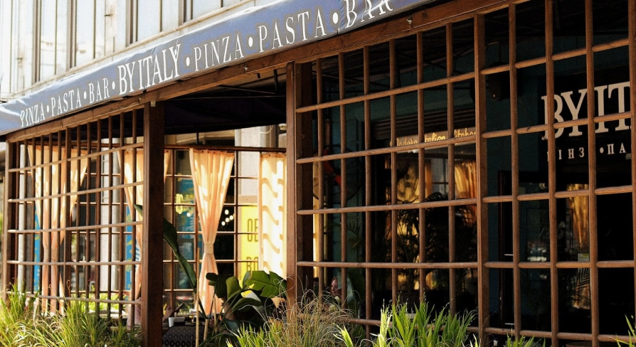 By Italy - elegant restaurant facade with large arched windows