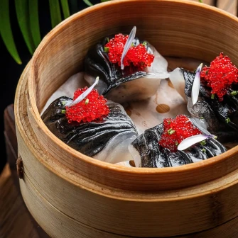 Black dim sum with red caviar in a bamboo steamer at NAM restaurant
