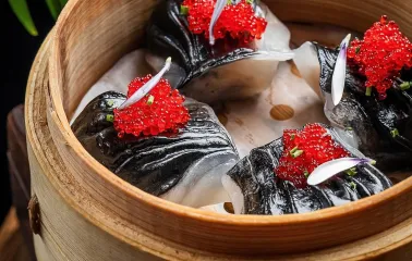 Black dim sum with red caviar in a bamboo steamer at NAM restaurant