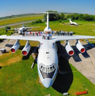 State Aviation Museum in Kyiv - massive white transport aircraft displayed on a green lawn with a large group of visitors standing on its wings