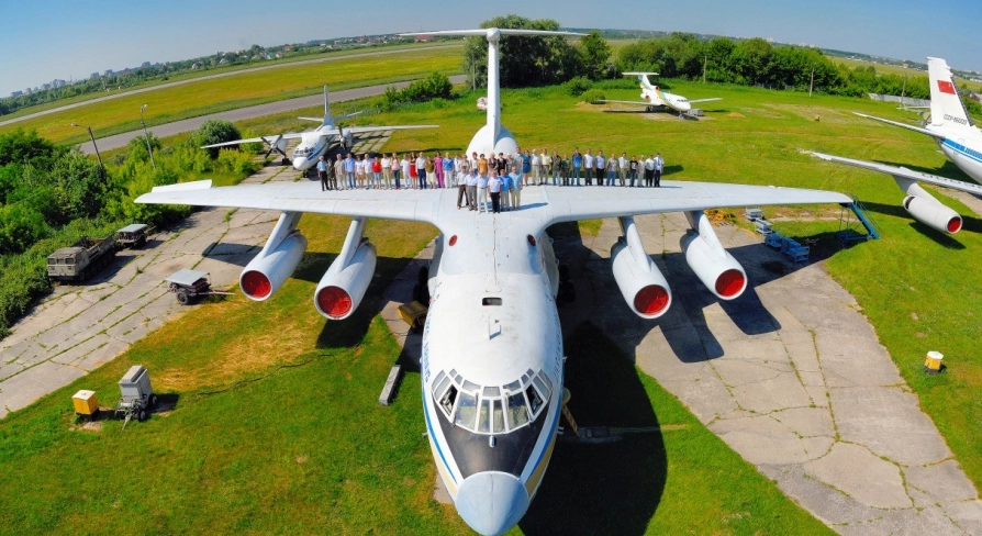 State Aviation Museum in Kyiv - massive white transport aircraft displayed on a green lawn with a large group of visitors standing on its wings