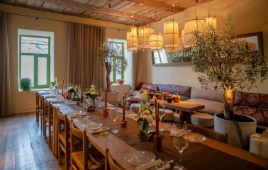 Seliam in Kyiv - dining room with long banquet table, olive trees and lanterns