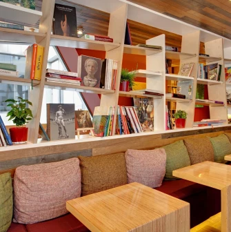 One Love Coffee in Kyiv - white shelves filled with art books above seating area