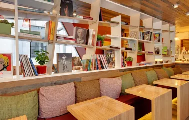 One Love Coffee in Kyiv - white shelves filled with art books above seating area