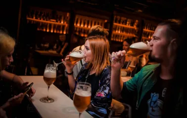 Pab Kedy - people drinking beer from goblets at a bright bar counter