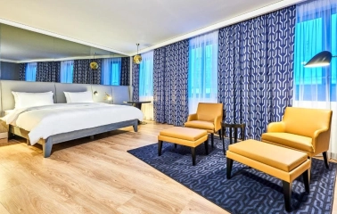 Spacious modern room at the Radisson Blu Hotel in the center of Kyiv with a double bed and a seating area