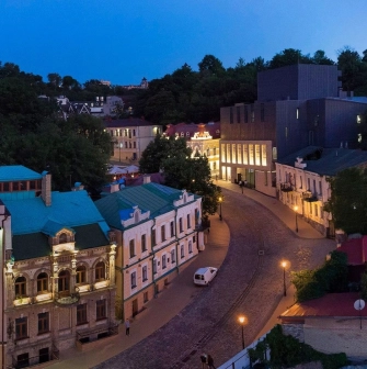 Teatr na Podoli in Kyiv - aerial evening view of the modern black theater building contrasting with the historic architecture of Andriyivskyy Descent