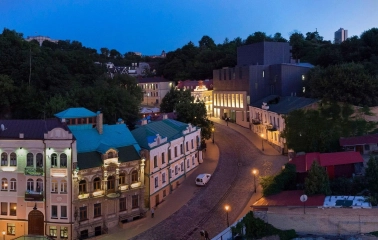 Teatr na Podoli in Kyiv - aerial evening view of the modern black theater building contrasting with the historic architecture of Andriyivskyy Descent