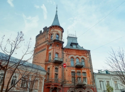Barons castle in Kyiv - red brick Gothic facade with a high tower and arched windows
