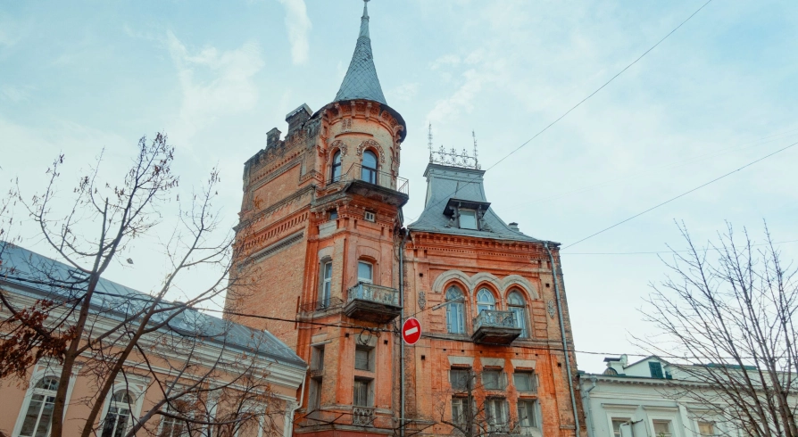 Barons castle in Kyiv - red brick Gothic facade with a high tower and arched windows