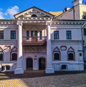 Muzei Hetmanstva in Kyiv - historic white manor house featuring a classic columned portico and a balcony with a Ukrainian flag
