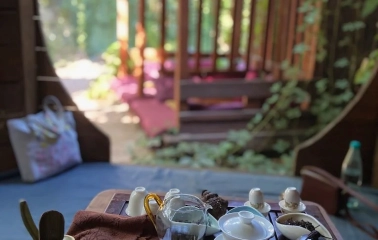 Chaguan in Kyiv - tea set with glass pitcher and white cups on wooden tray outdoors