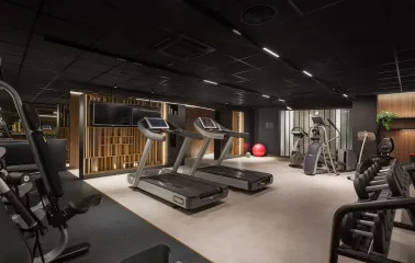 Radisson Blu - well-lit hotel fitness center with cardio equipment and weights