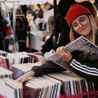 A girl in a red hat looks through records at the Podilsky Shuk vintage market in Kyiv
