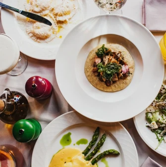 Resraurant Under Wonder - close-up of two artfully plated dishes with gourmet ingredients on a dining table