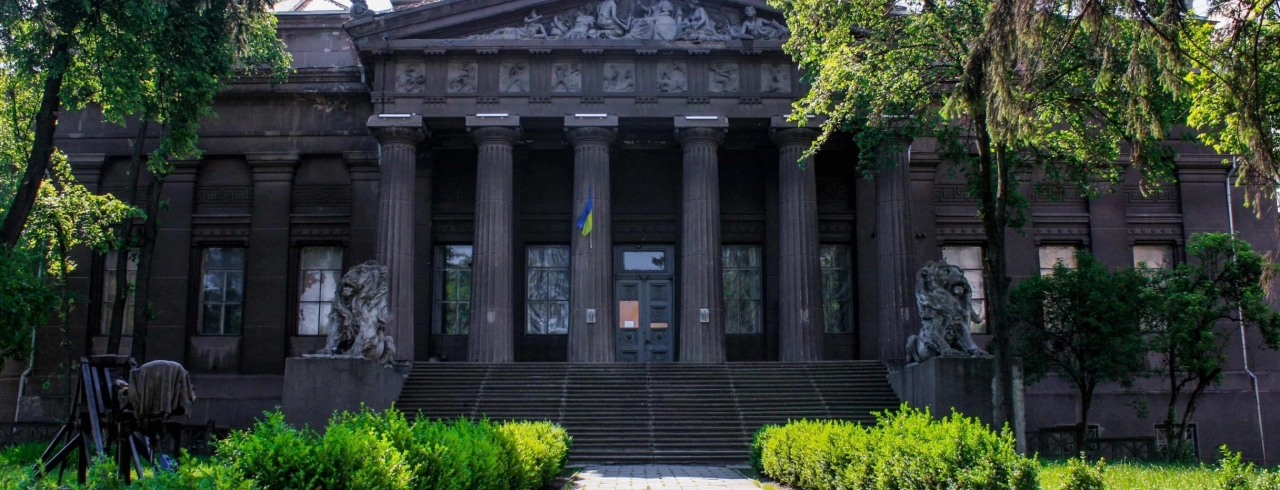 Natsionalnyi Khudozhnii Muzei Ukrainy in Kyiv - majestic dark grey classical facade with a Greek portico and lion sculptures guarding the entrance stairs