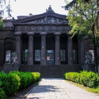Natsionalnyi Khudozhnii Muzei Ukrainy in Kyiv - majestic dark grey classical facade with a Greek portico and lion sculptures guarding the entrance stairs