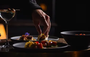 Serving dishes with plates and a cocktail at the restaurant