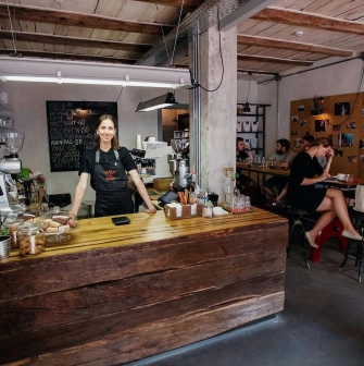 Svit Kavy in Kyiv - interior featuring wooden bar counter and smiling barista