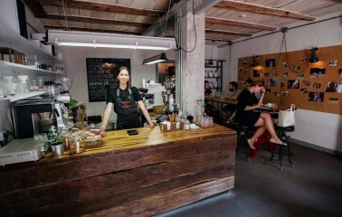 Svit Kavy in Kyiv - interior featuring wooden bar counter and smiling barista