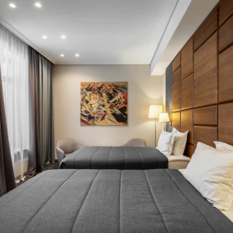 City Hotel in Kyiv - hotel room with two twin beds, wooden wall panel and painting